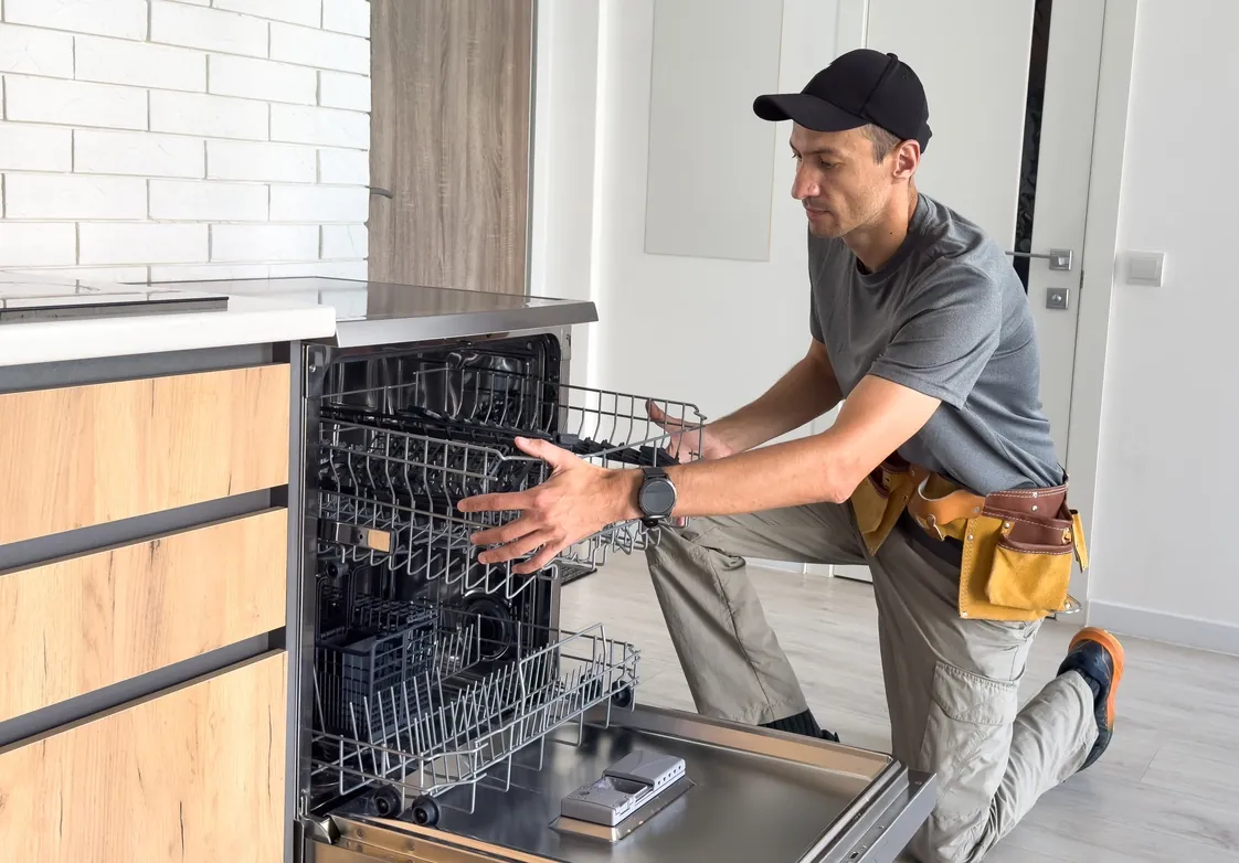 Appliance engineer repairing a dishwasher in a Bristol home