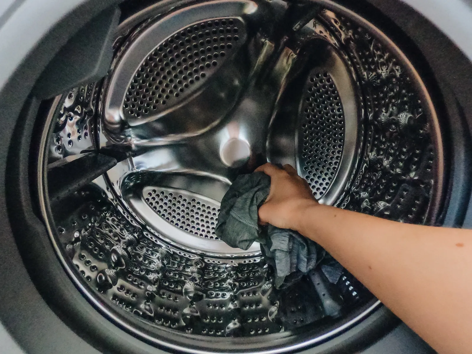 Washing being loaded into a repaired washing machine