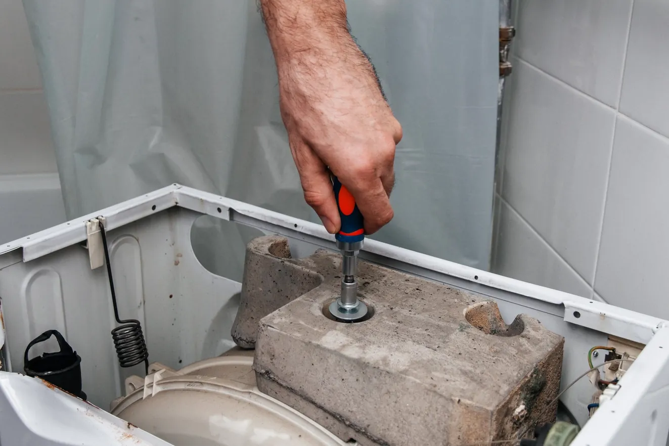 Engineer repairing a washing machine in a Bristol home